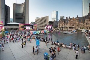 Large crowd watching a sporting event on a big screen in downtown Toronto public square